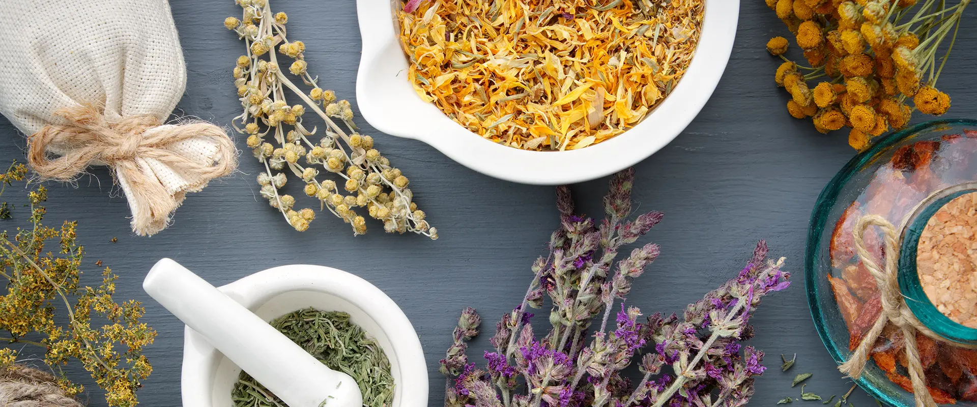 Medicinal herbs, mortar of healing herbs, sachet and bottle of drugs on wooden table. Herbal medicine